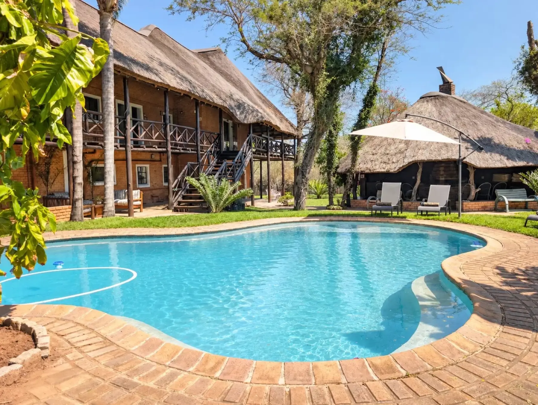 Thatched lodge and pool at Leriti Safari House, Marloth Park.